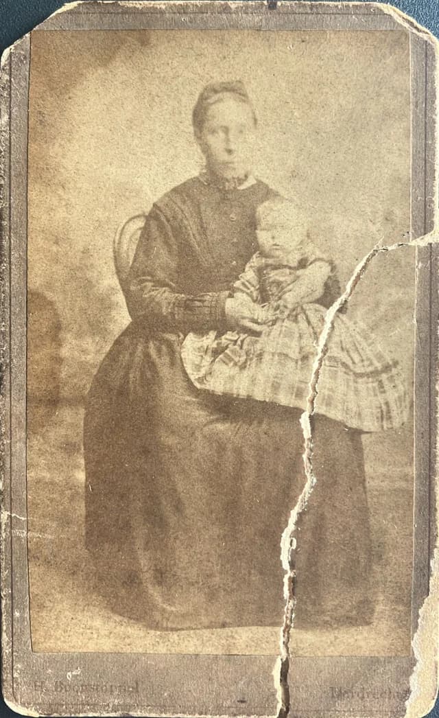 Torn vintage photo of mother and baby